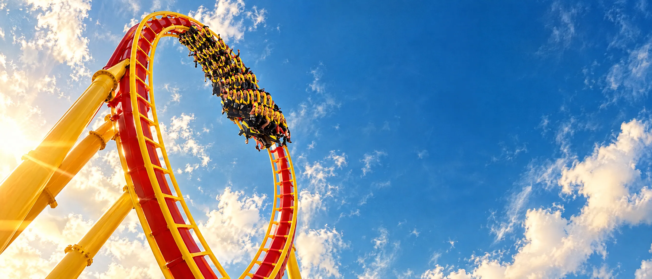 Nitro's red and yellow track loops against a bright blue sky, full of riders